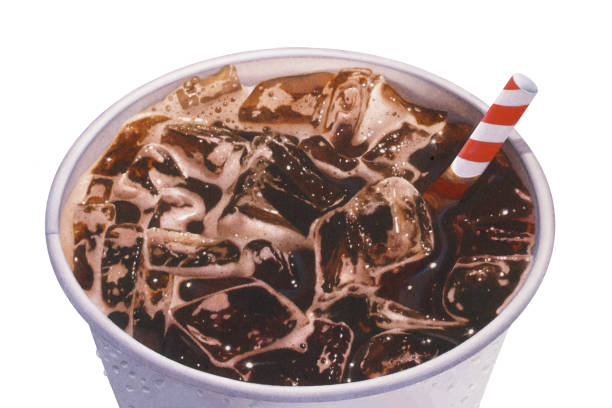 An aerial view of a cup of soda, with ice and a straw.