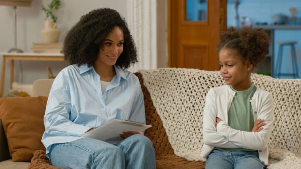 istock African American child psychologist talking conversation dialogue together teamwork daughter kid little girl woman writing smiling happiness mental health contact psychotherapy patient specialist glad 2191997704