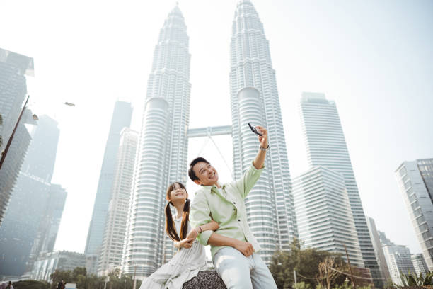 Asian father and daughter taking selfie while travel in Kuala Lumpur. stock photo