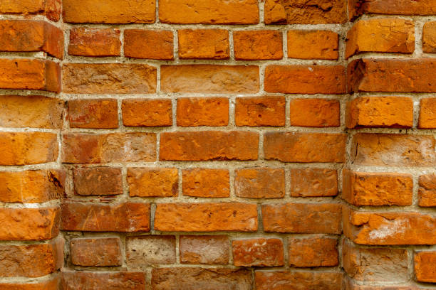 Traditional red brick wall showcases distinct textures and colors, highlighting craftsmanship and durability in construction