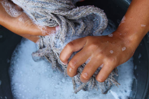 istock hands wringing out a mop full of soap suds 2192004381