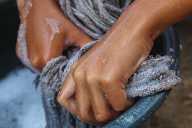 istock hands wringing out a mop full of soap suds 2192004383