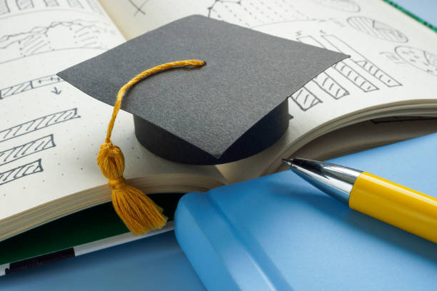 istock Graduation cap on a notebook with business notes. Symbol of education. 2192005965