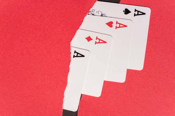 Aces of playing cards lined up on a red background