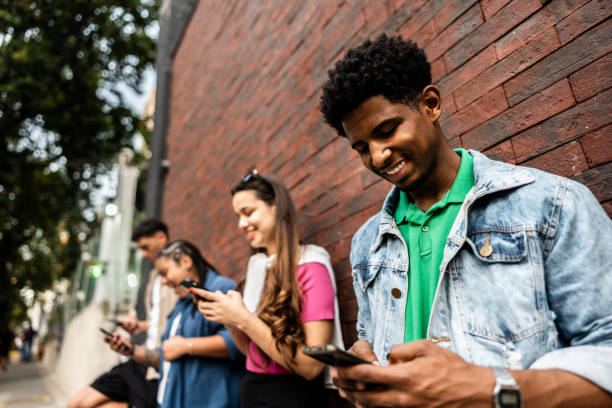 istock Young man using the mobile phone in the street with friends 2192012575