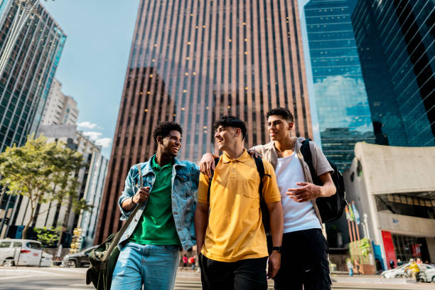 istock Young friends talking while walking in the street 2192012708