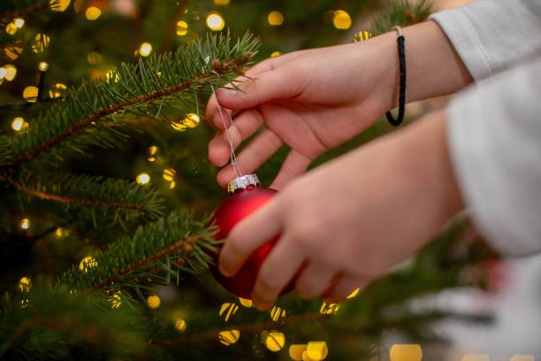 istock Decorating a Christmas Tree with a bright red ornament is a cherished family tradition 2192013965