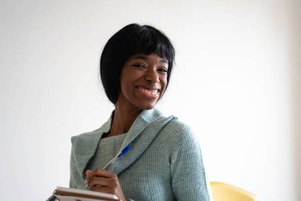 istock Smiling african american college student on campus making notes on notepad - Focus on woman eyes - Horizontal portrait 2192015683