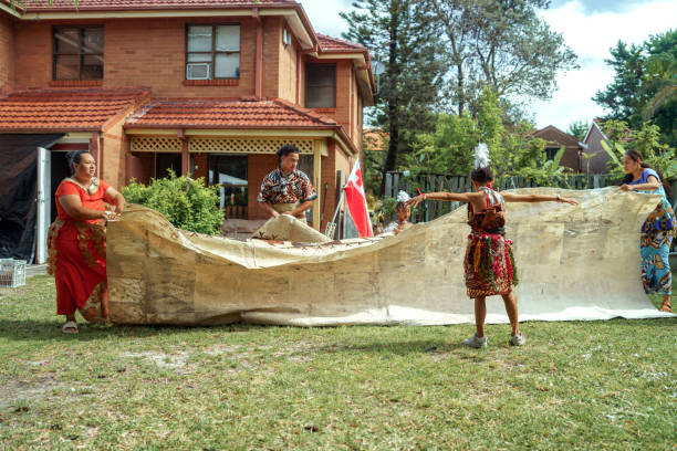 Pacific Islanders family getting ready for traditional dance at their back yard, unfolding carpet
