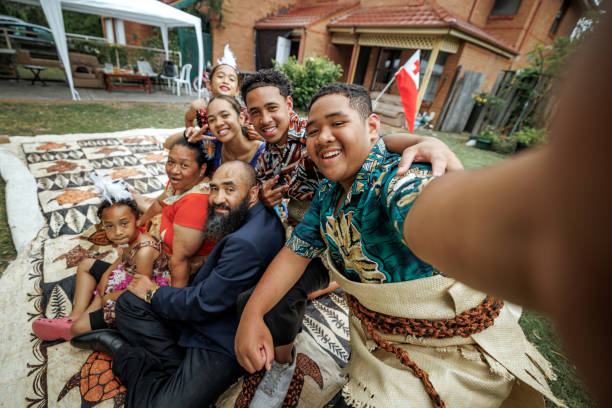 istock Big Pacific Islanders family taking selfie while sitting on a carpet and wearing traditional clothes 2192016697