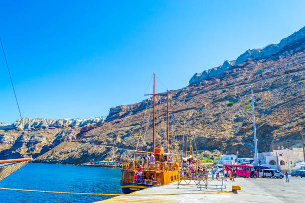 Thira Port at Santorini island Cyclades Greece. View of Santorini port from tour boat deck in the Caldera-Mostly submerged volcanic crater with quaint hillside lodging, boat tours and panoramic seaside views. Athinios Ferry Port terminal at he coast,Aegean Sea,Cyclades,Greece