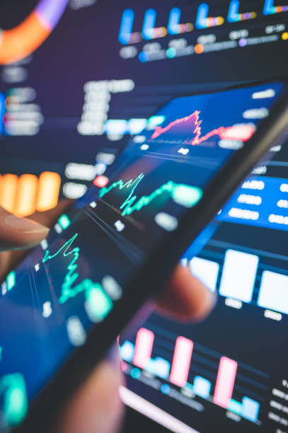 istock Senior investor interacts with a modern trading interface, navigating vivid stock charts and market trends. Perfect for illustrating financial forecasting and strategies amidst market fluctuations. 2192021662