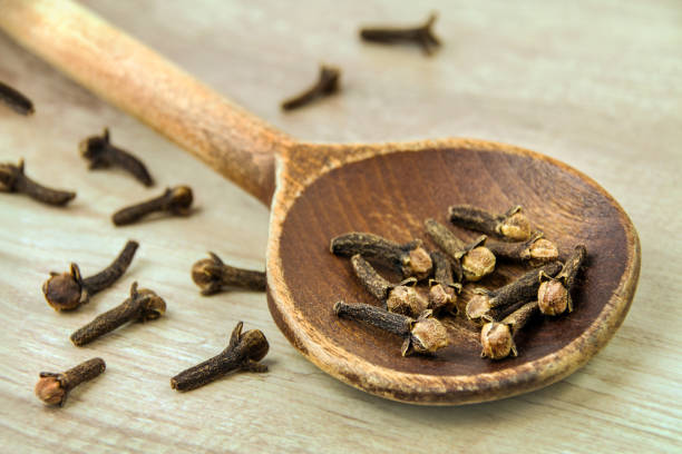 istock Cloves and spoon on wooden background 2192033523