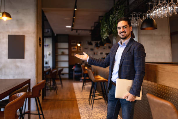 istock Restaurant manager showing his establishment with a welcoming gesture 2192037501