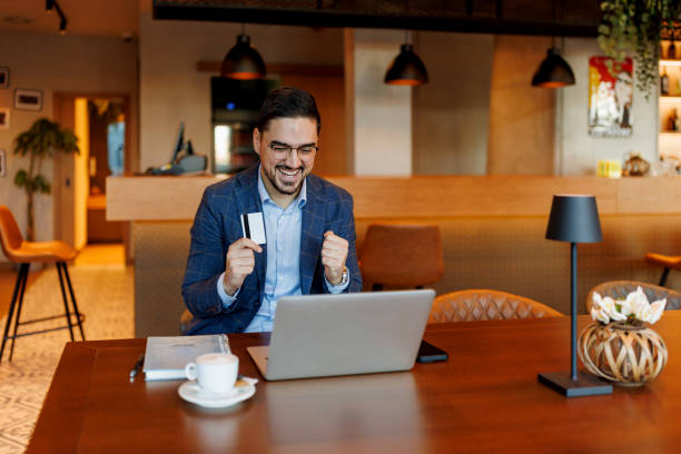 istock Businessman celebrating successful online shopping with credit card 2192037607