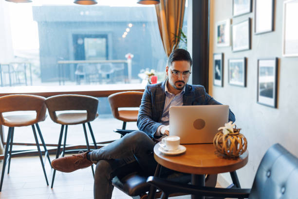 istock Businessman working on laptop in a cafe 2192037772
