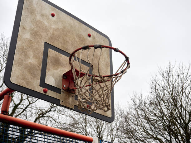 istock Weathered basketball hoop against a cloudy sky in an outdoor setting. 2192039607