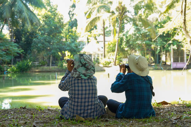 istock Two Asian boys use binoculars to study the local birds at school. Soft and selective focus. 2192042744