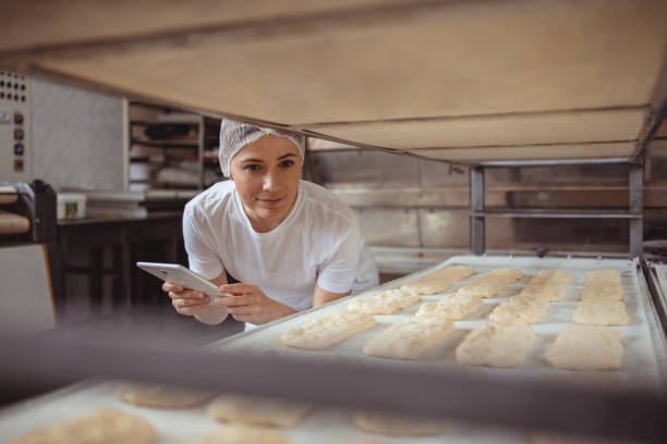 istock Female Baker Managing Orders with Digital Tablet in a Bakery 2192044421