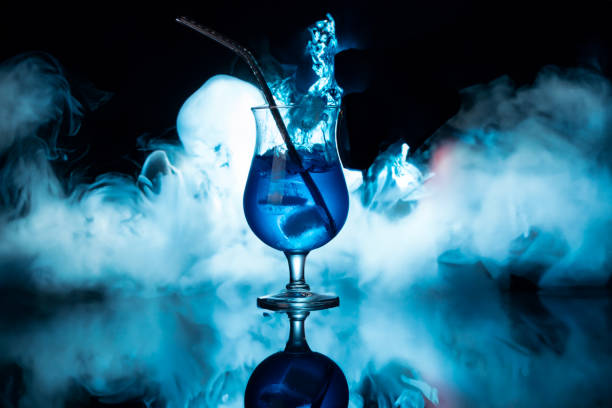 istock Blue coctail glass with tequila on reflection table on dark background oin night club. 2192049285