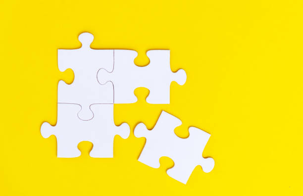 istock Four white puzzle pieces comes together on yellow background 2192049792