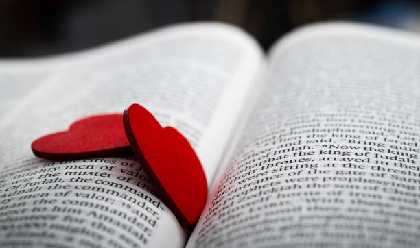 istock Two red heart shapes on an open book 2192049925