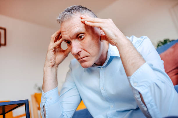 A lonely man showing unhappy face while having problems at home and looking worried