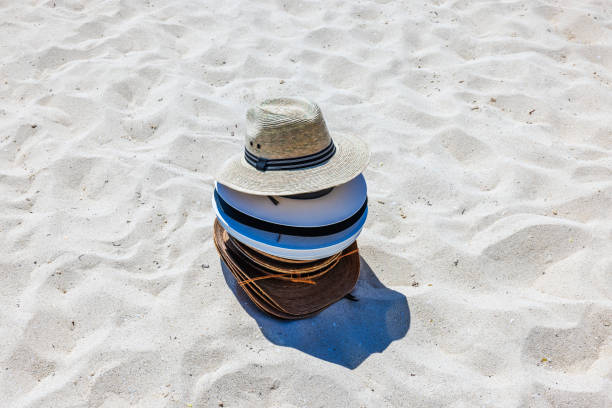 Cabo San Lucas, Mexico-January 4, 2014:  Man selling straw hats on beach to tourists.