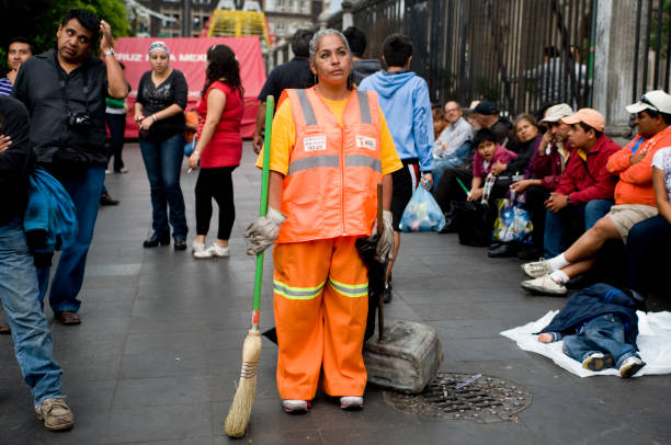 A sanitary worker takes a moments break and stares off into the distance during the Bicentennial Celebrations of Mexico's independence from Spain, and Centennial celebrations of the Mexican Revolution.  Zocalo, Mexico City. September 15 2010