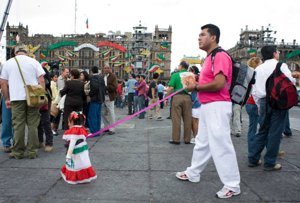 A man and his daughter. Bicentenial Celebrations of Mexico's independence from Spain, and Centenial celebrations of the Mexican Revolution.  Zocalo, Mexico City. September 15 2010