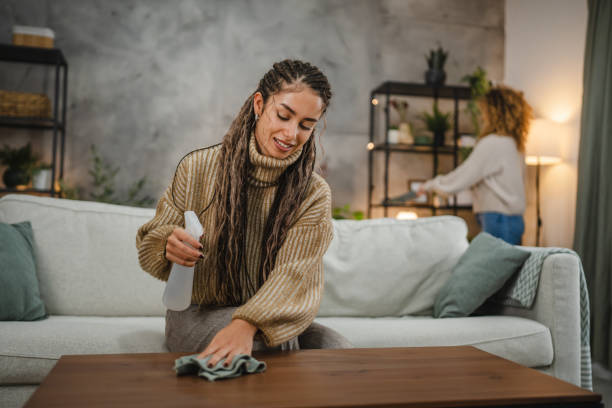 istock Young woman wipe dust use spray and green fabric cleaning on table 2192064156