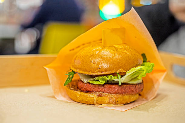 istock hamburger with cheese, lettuce, pickle and vegetarian cutlet on tray on light background. quick snack 2192066820