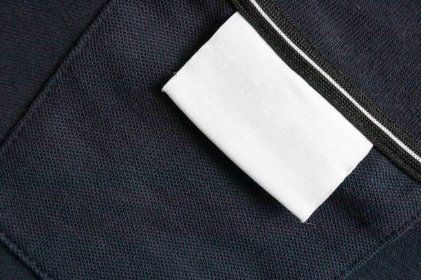 istock Blank white laundry care clothes label on black shirt fabric texture background 2192076295