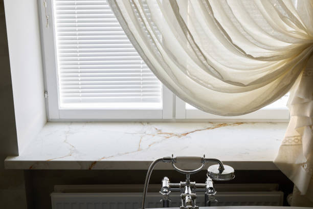 istock An Elegant Window Featuring Soft Cream Curtains and a Stylish Marble Sill Beneath 2192078580