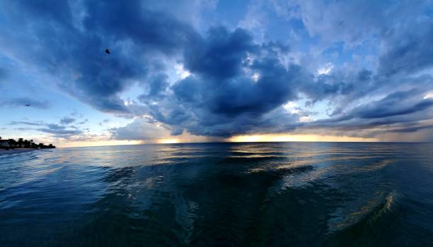 Isolated Rainstorms off of the beach at sunset in Indian Rocks Beach, FL 9/24/24 Tampa Bay St. Petersburg Pinellas County Florida USA. Cloudscapes, Waves, Sand, Turbulent Skies