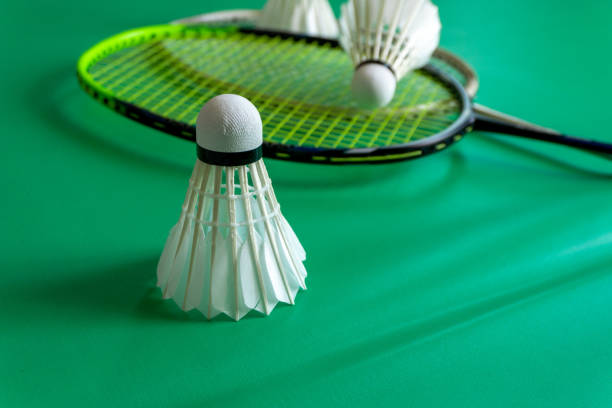 Badminton rackets and shuttlecocks on green background. copy space