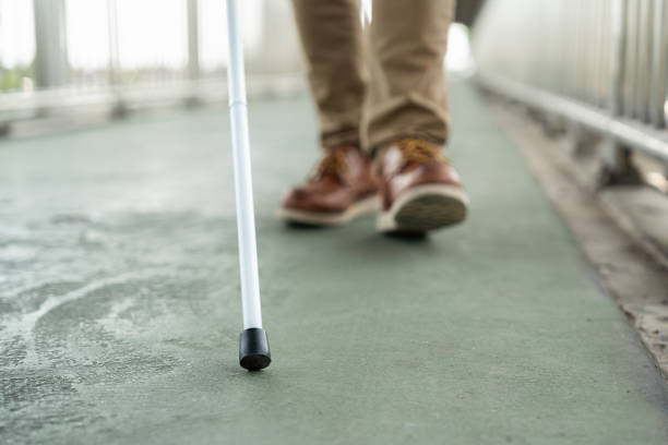 istock Young blind man walking in city with walking stick. Visually impaired man difficult to traveling on the road wearing sun glasses Cross the road cross the footbridge 2192085101