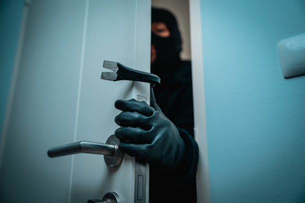 istock Thief in uniform black jacket various action housebreak. The Robber terrorism criminal escapes with balaclava and crowbar entering a house for stealing Housebreak at night 2192085125