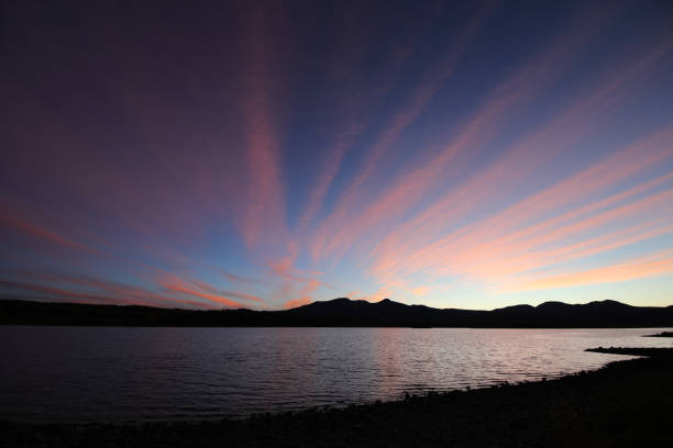 At sunset, the mountains quietly nestle against the water, like a quiet picture.