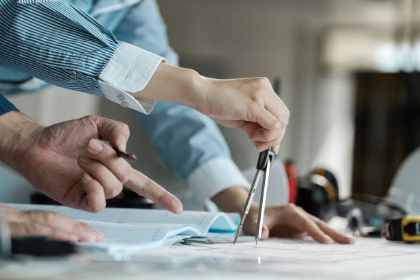 istock Engineer and architect collaborate on blueprint design in modern office environment with detailed technical planning 2192087754