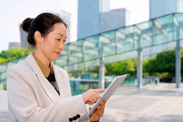 istock Professional Businesswoman Engaged with Tablet in Urban Setting 2192089793