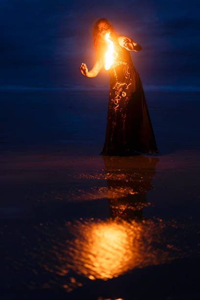 Fire dancer performing at night on Second Beach, Tofino, Vancouver Island, British Columbia, Canada