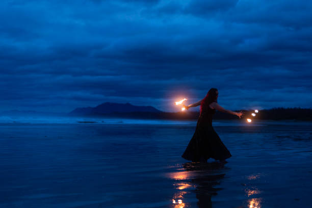 istock Female with fire fingers dancing on the beach 2192091603
