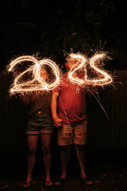 istock Two people writing the numbers 2025 with sparklers 2192094992