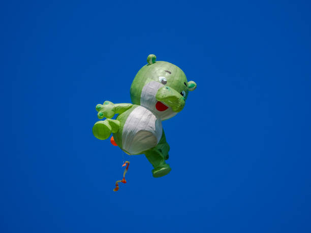 Low Angle View Of Green Helium Balloon Flying Against Clear Blue Sky
