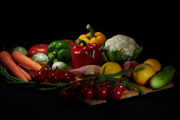 Fresh vegetables for cooking or eating raw are placed on a tray or place to be photographed with a dark background