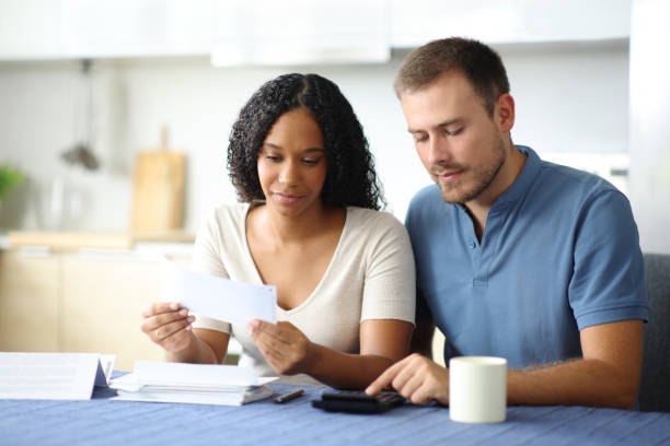istock Interracial couple calculating expenses in the kitchen 2192102538