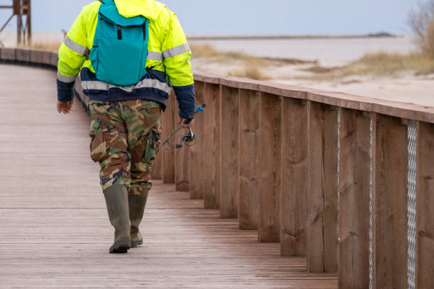 istock .An angler with a spinning wheel in his hands walks along the boardwalk in rubber boots 2192102654