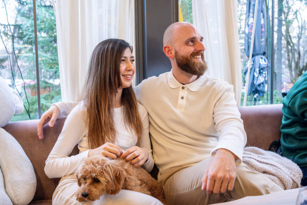 istock A cheerful young family with their pet Cavapoo dog in a cafe. 2192102848