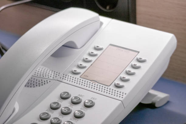 A vintage cordless telephone and answering machine sit on a lace doily, evoking nostalgia for a time before smartphones in a cozy, domestic setting